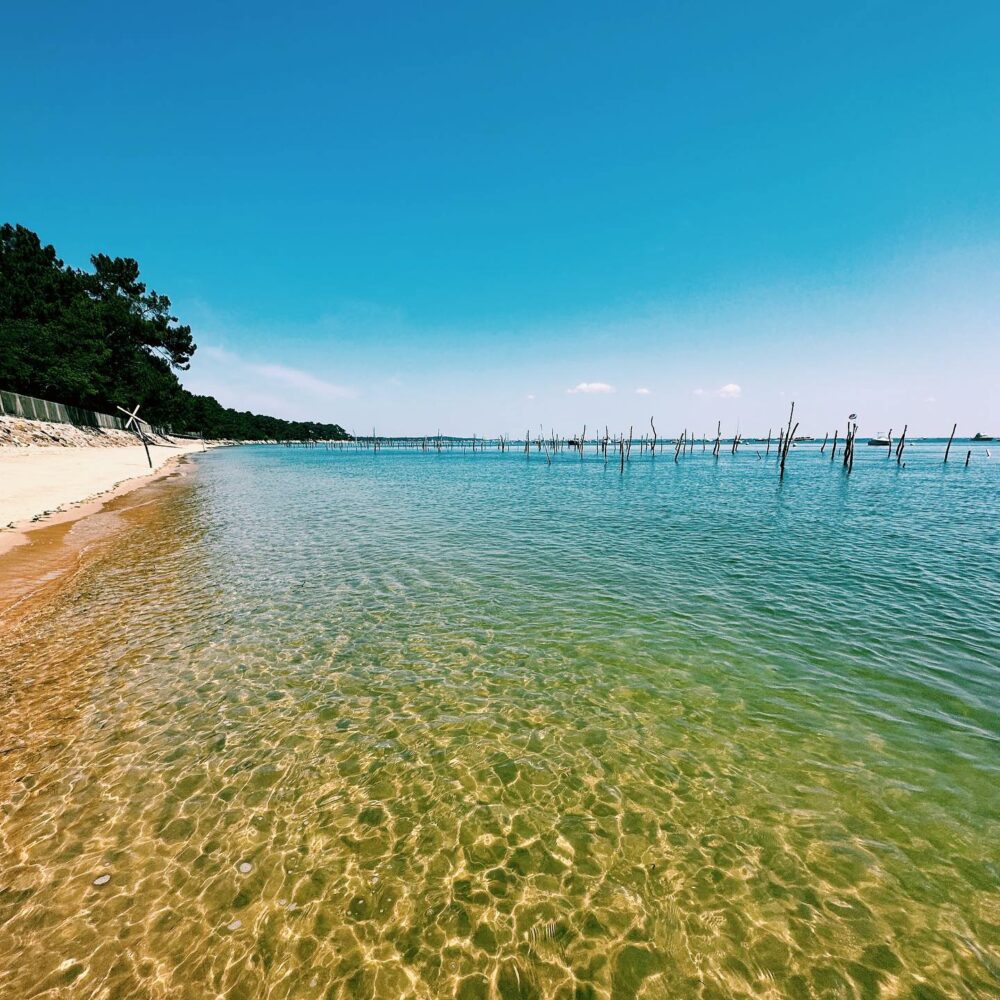 Plage entre la Vigne et L'Herbe au Cap Ferret, ciel bleu et mer turquoise